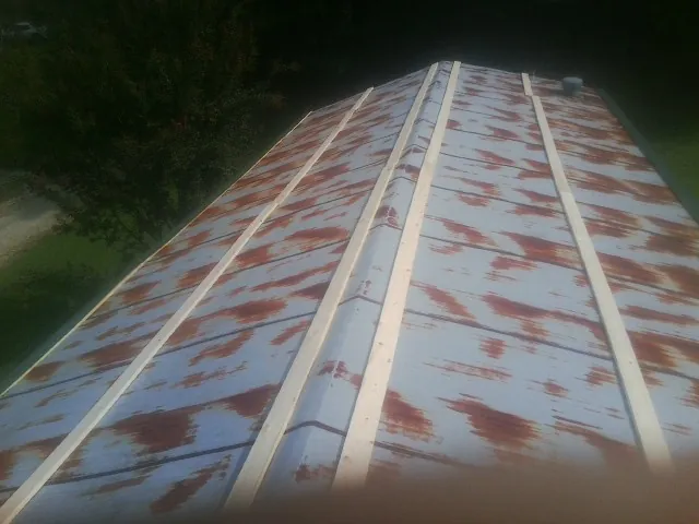 Rusted metal roof panels with new wood purlins before replacement — Storm Damage Roof Repair in Mount Sterling by Roofing Brothers